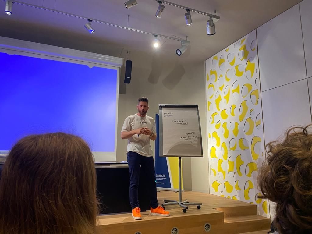 Bob Offreins geeft coaching vanaf het podium, hij maakt gebruik van een flip-over