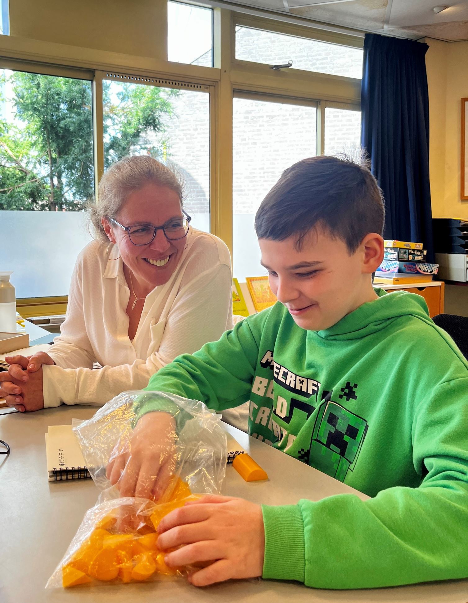 Dean doet een oefening met ruimtelijke figuren met zijn juf