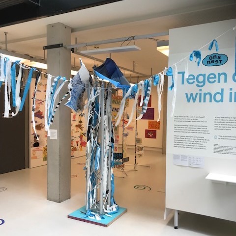 Object met blauwe en witte lappen aan een lijn en aan een paal