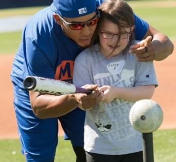 Meisje met honkbalknuppel krijgt les van slagman