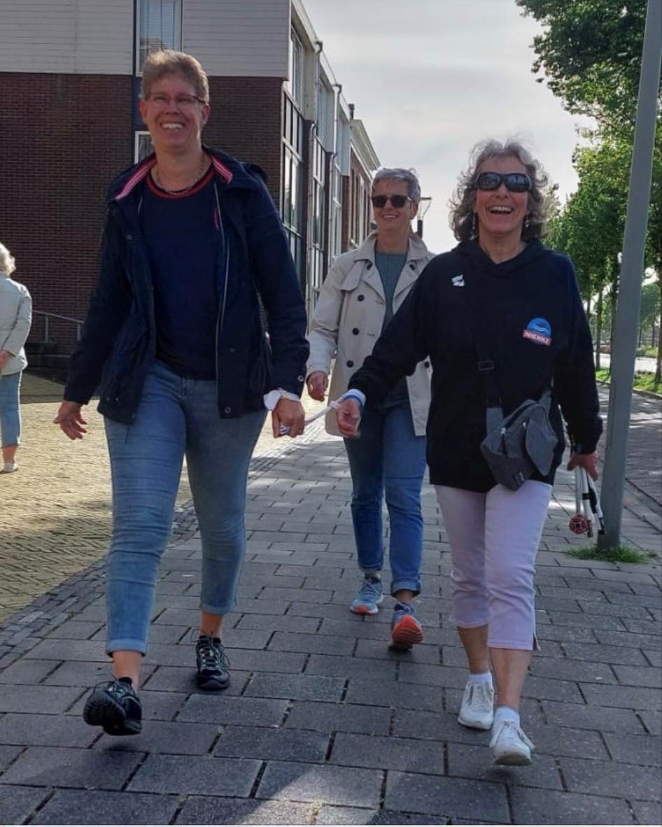 Sylvia de Munnik wandelt mee tijdens de Avondvierdaagse terwijl zij met een band verbonden is aan haar wandelbuddy