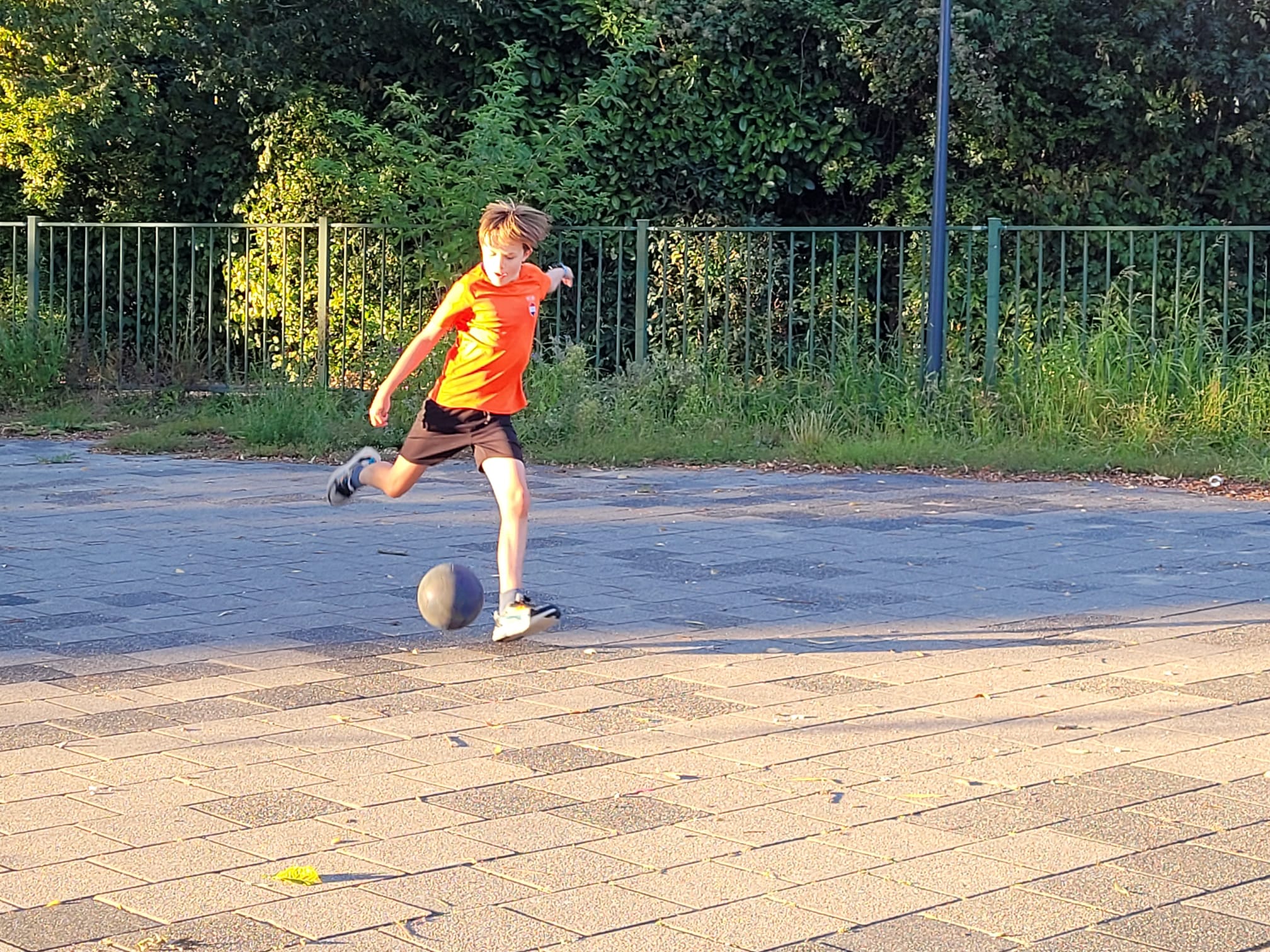 Fabian voetbalt alleen op betegeld veldje en schopt tegen de bal