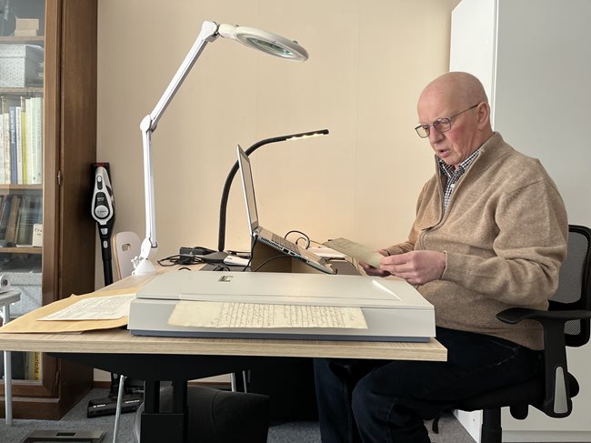Meneer de Brabnder achter zijn bureau met een daglichtlamp en vergrotingsapparaten