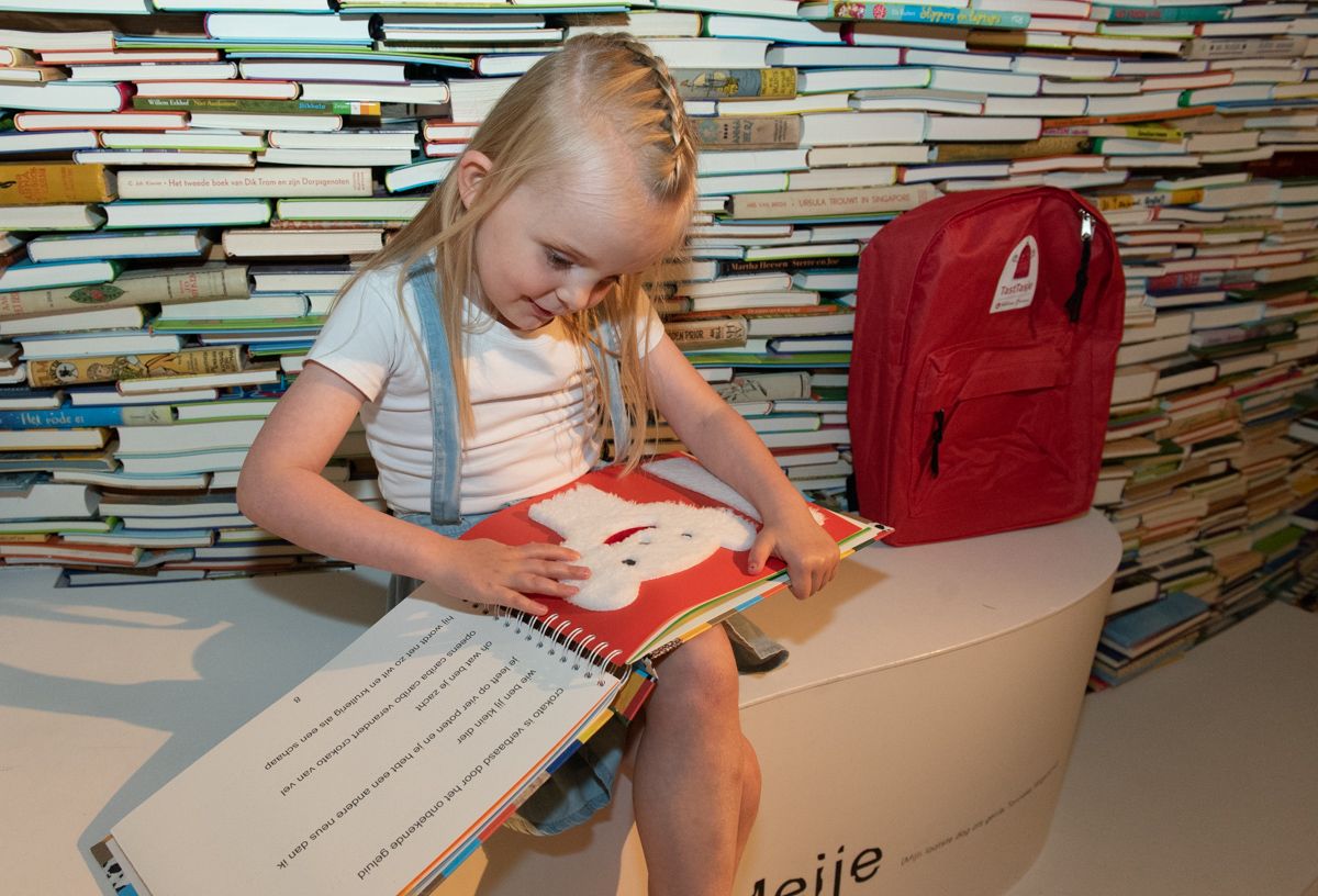 Meisje leest in tastboekje