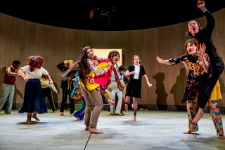 Op de foto is het podium te zien, met de acteurs. Ze zijn mid-beweging.