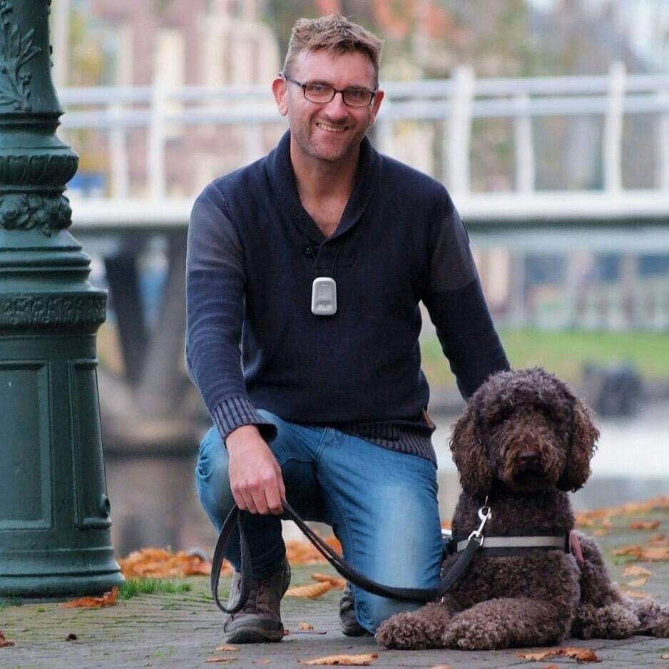 Collin en zijn geleidehond, een bruine labradoodle
